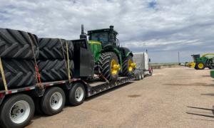 Large farm tractor and oversized tires loaded on trailer by Oden Transport.